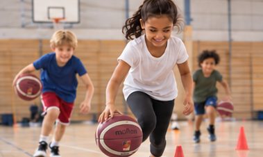 Kids dribbling around cones in the gym (AI-generated image)