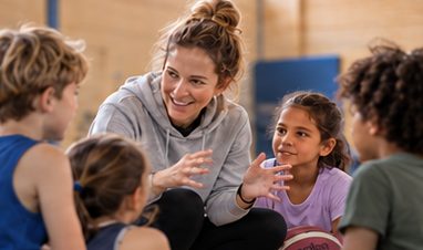 Coach kneeling with the kids and explaining a drill (AI-generated image)